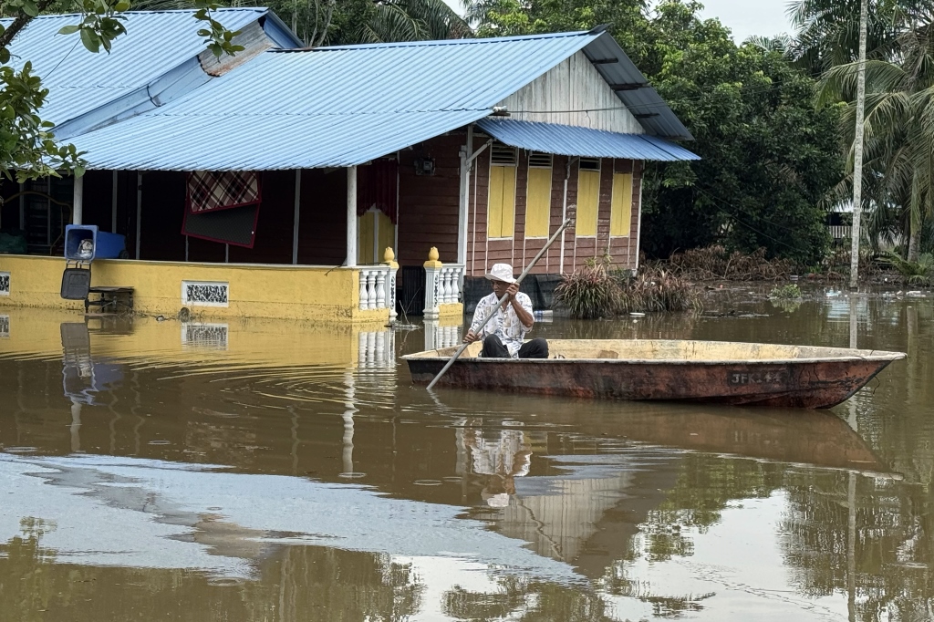 Flood victims use canoes to survey houses